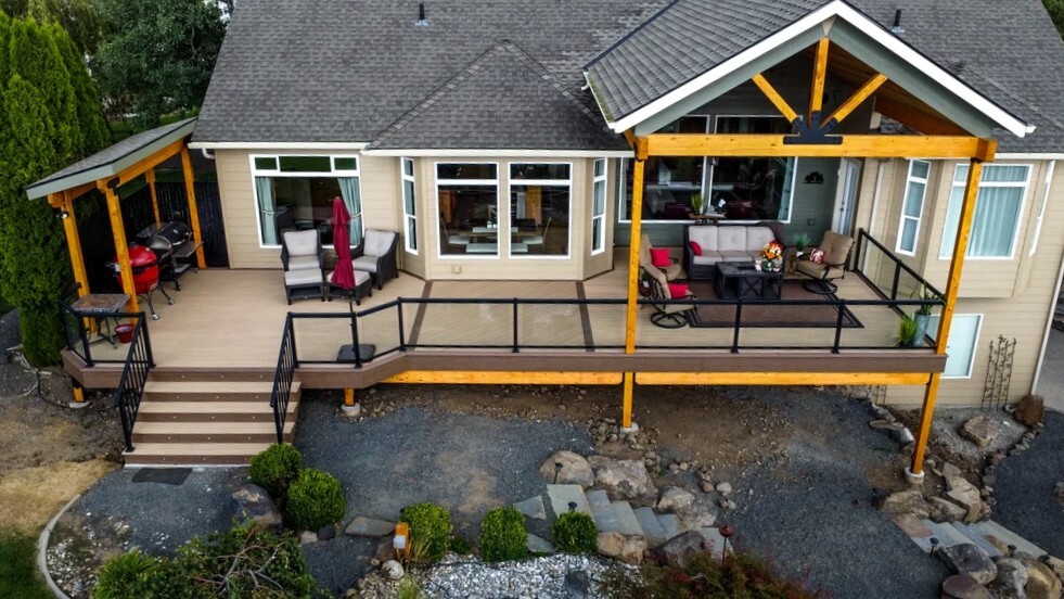 Furnished outdoor living deck with covered seating and grilling areas