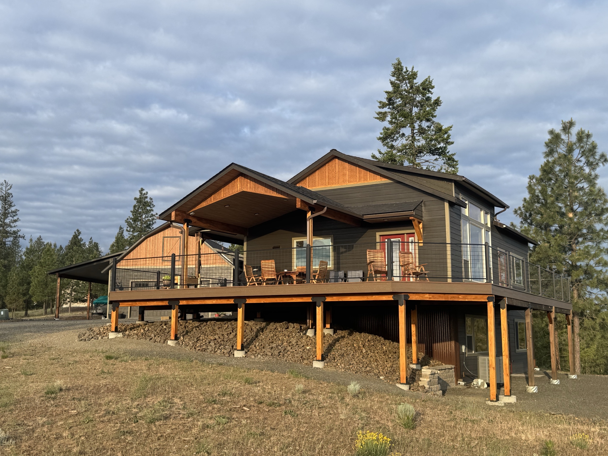 Large custom elevated deck with covered outdoor living area by Dynamic Decks
