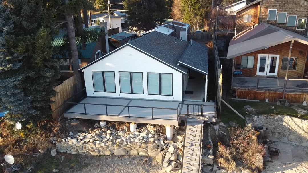 Aerial view of a custom residential deck with glass railing and stairs