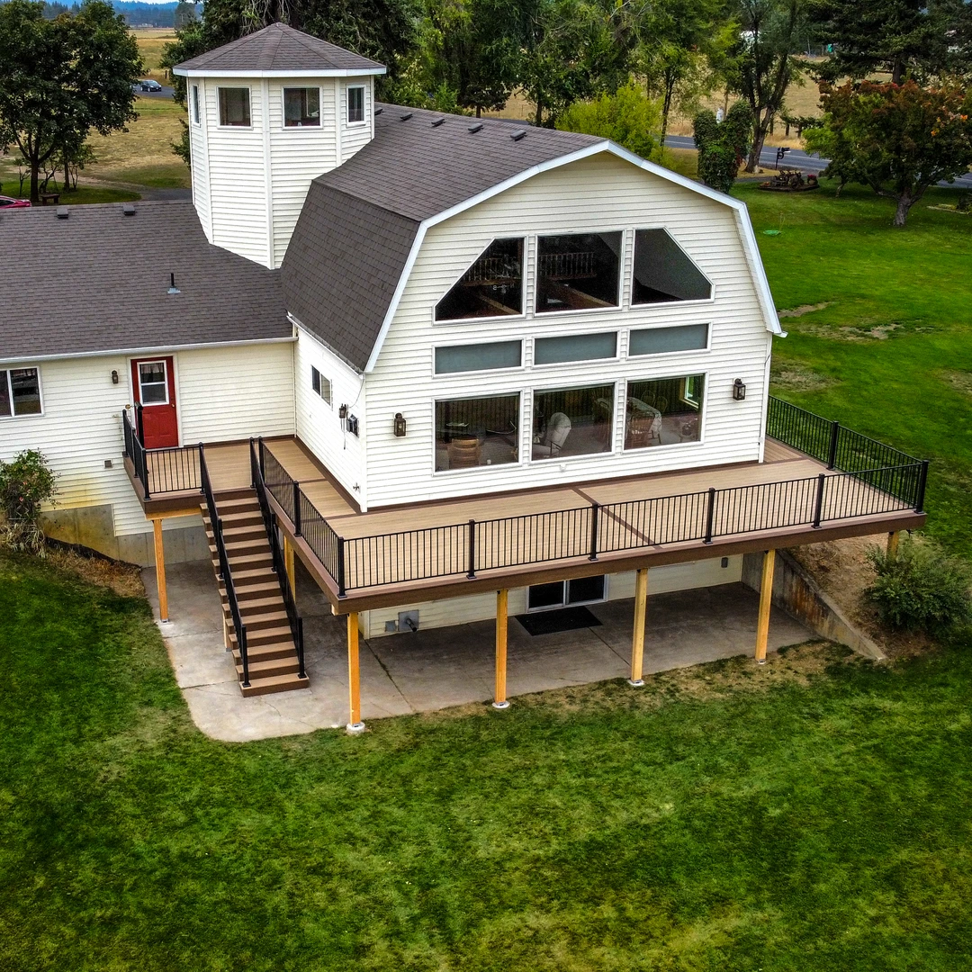 Completed wraparound residential deck with black railing and stairs